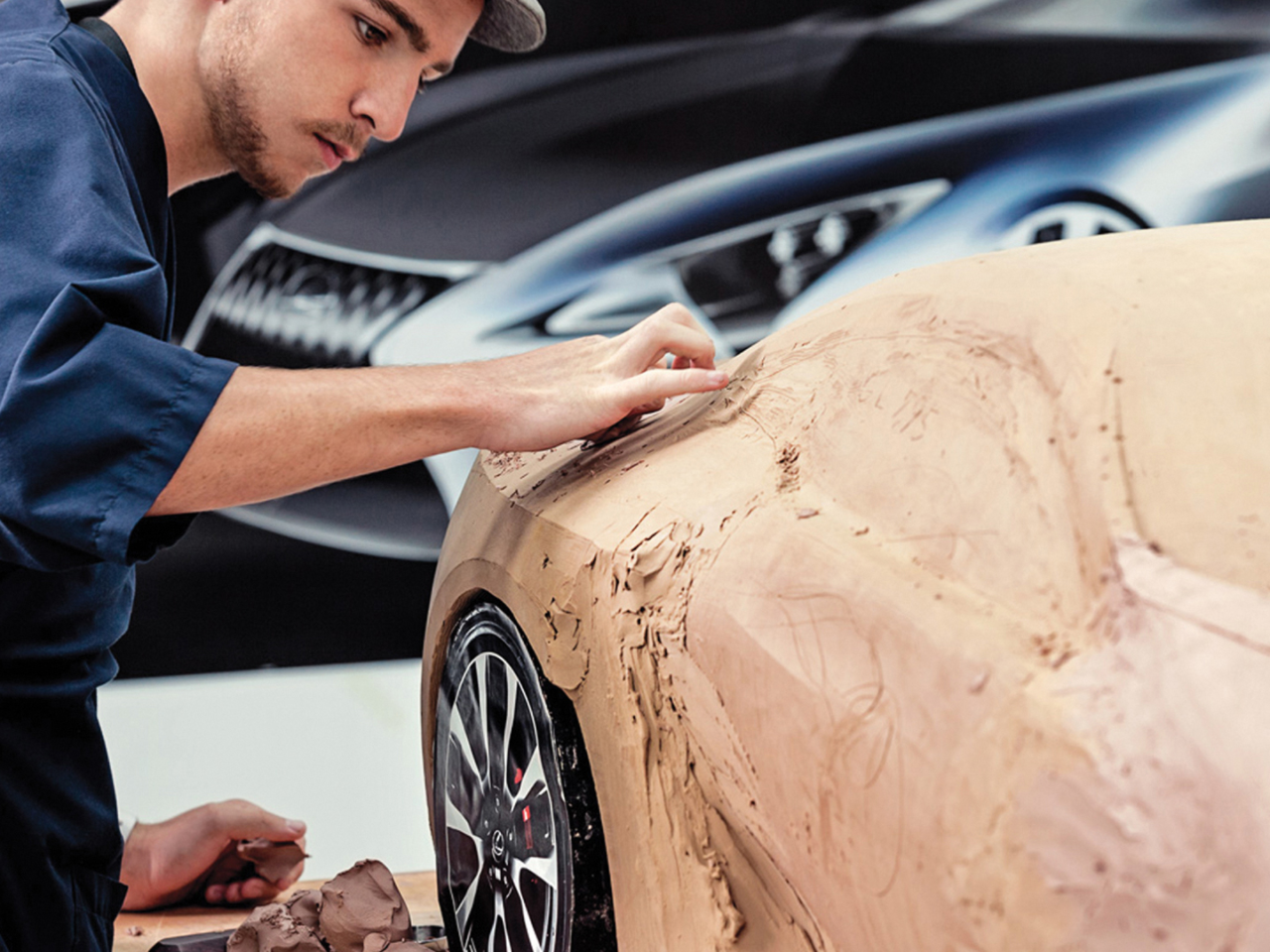 A person carving a clay Lexus model