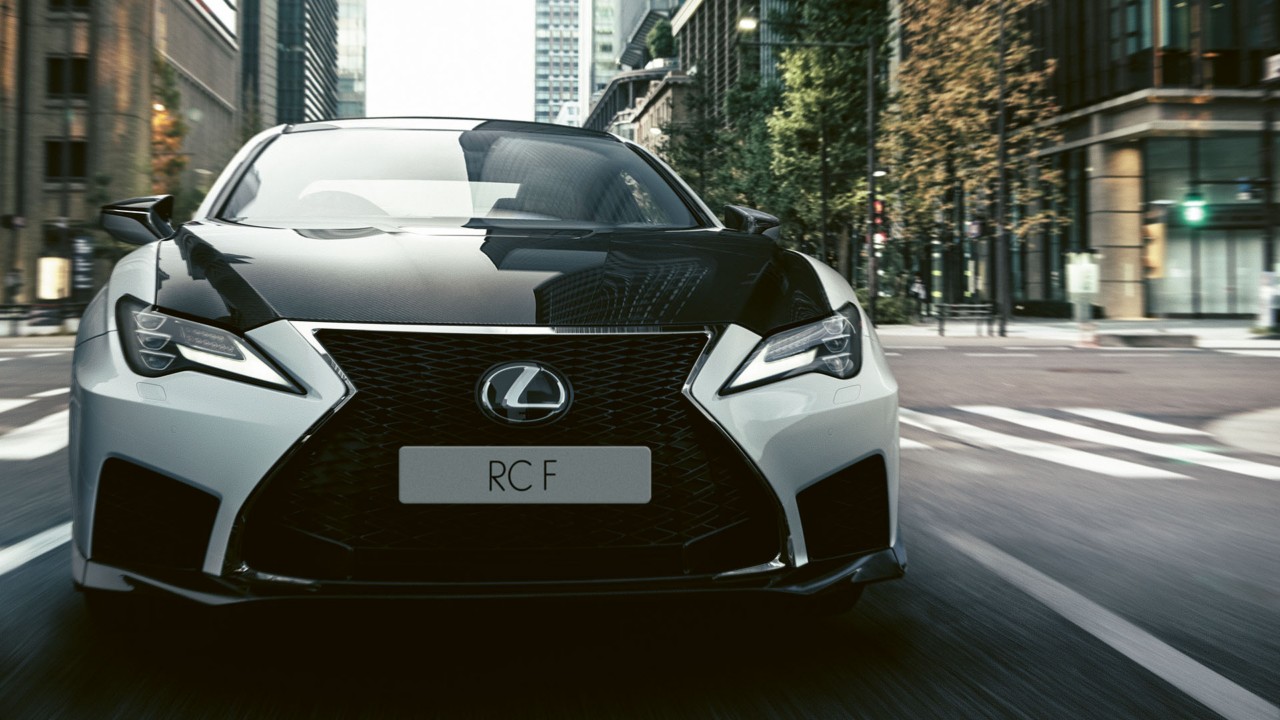 A front close-up of the Lexus RC F driving through a city street