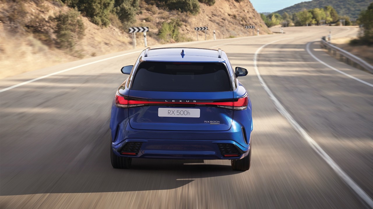 Rear view of the Lexus RX 500h driving on a road