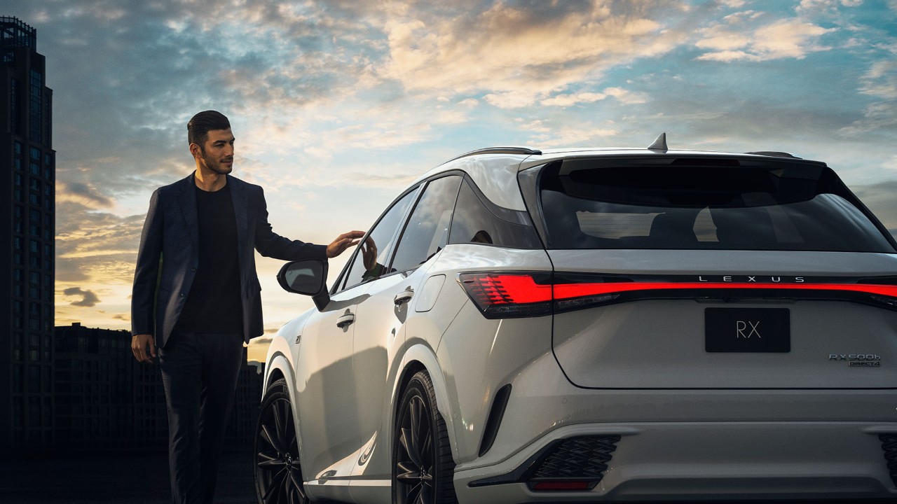 A man with his hand on the Lexus RX