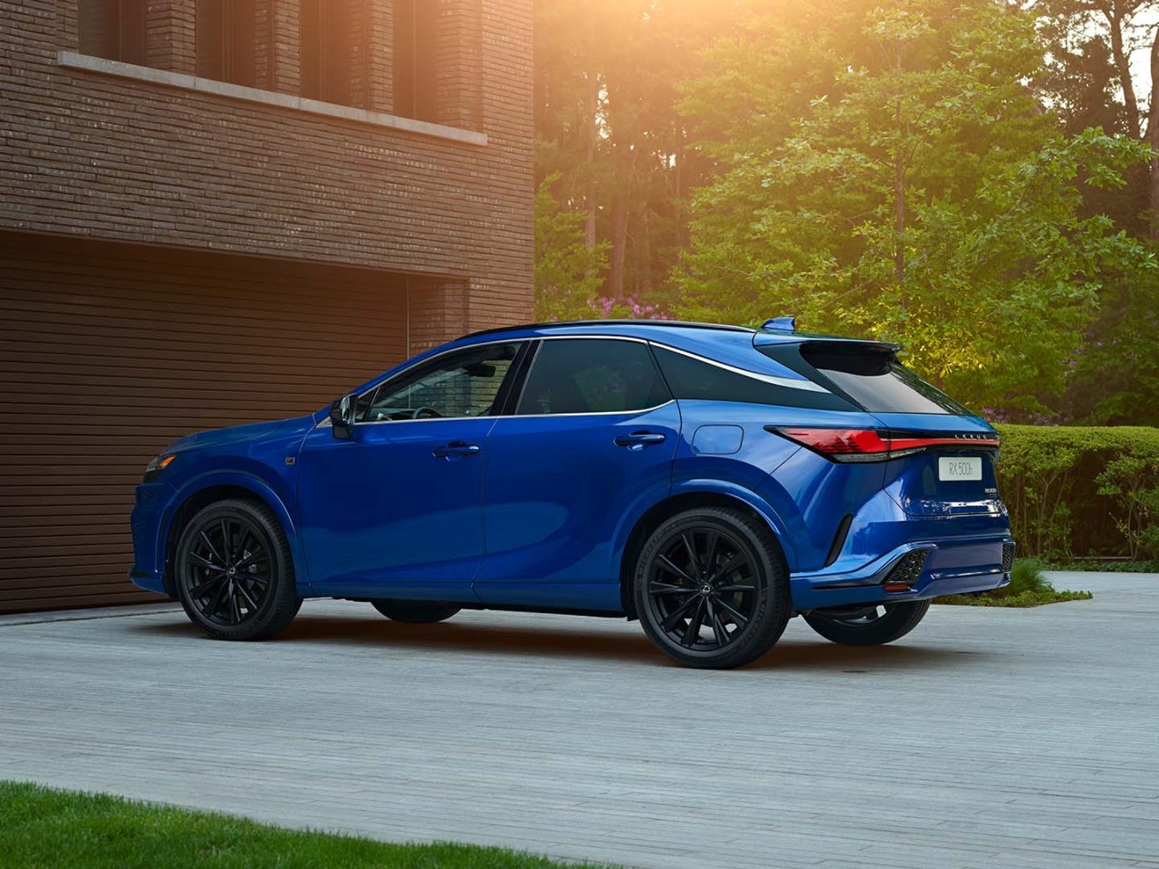 Side view of the Lexus RX 500h parked on a driveway 