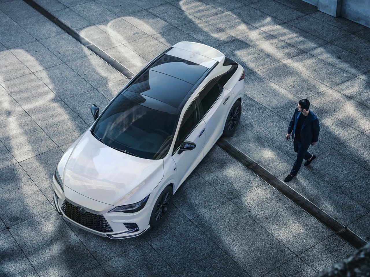 A man walking towards a Lexus RX