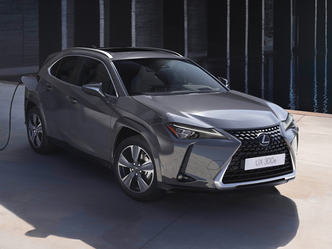 A Lexus UX 300e plugged into a charging tower