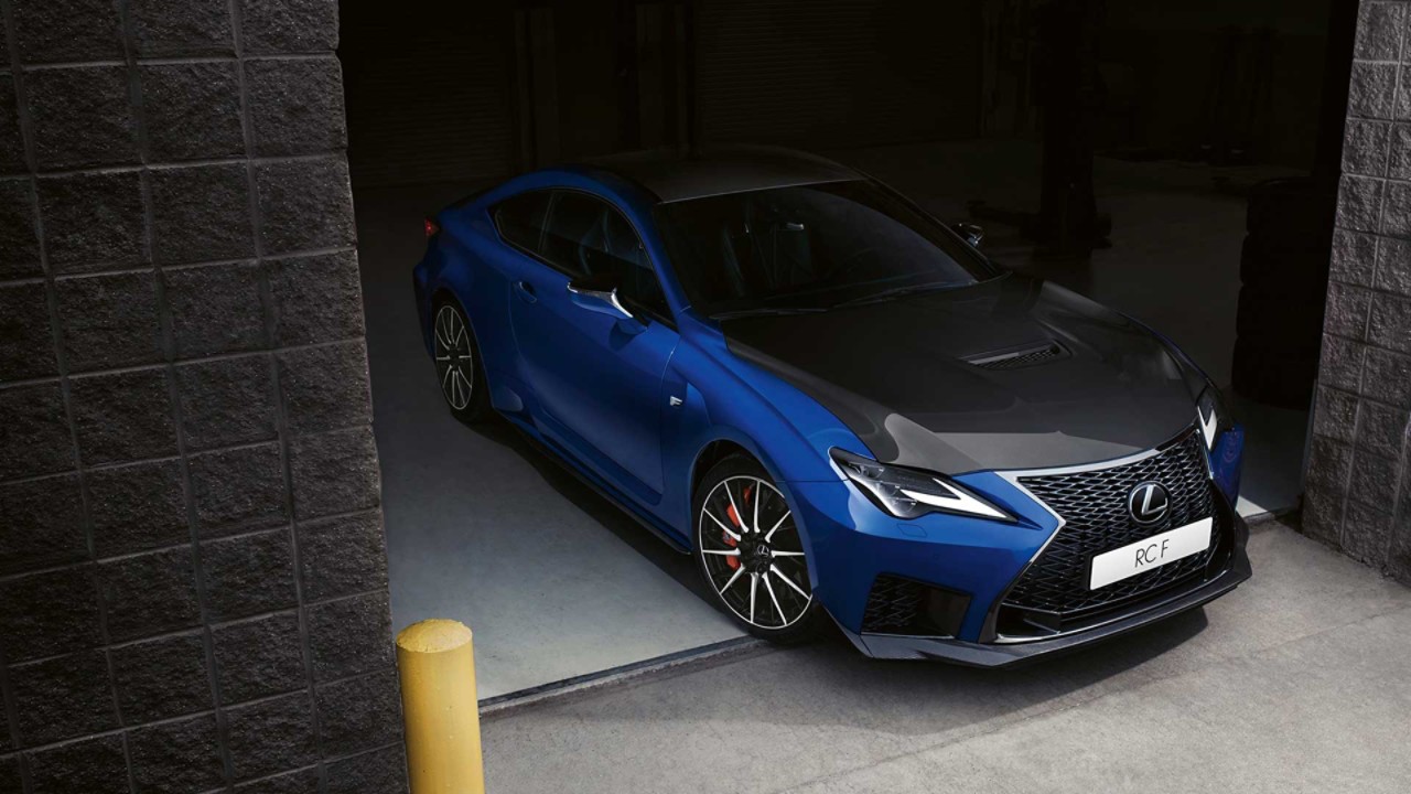 A front close-up of the Lexus RC F driving through a city street