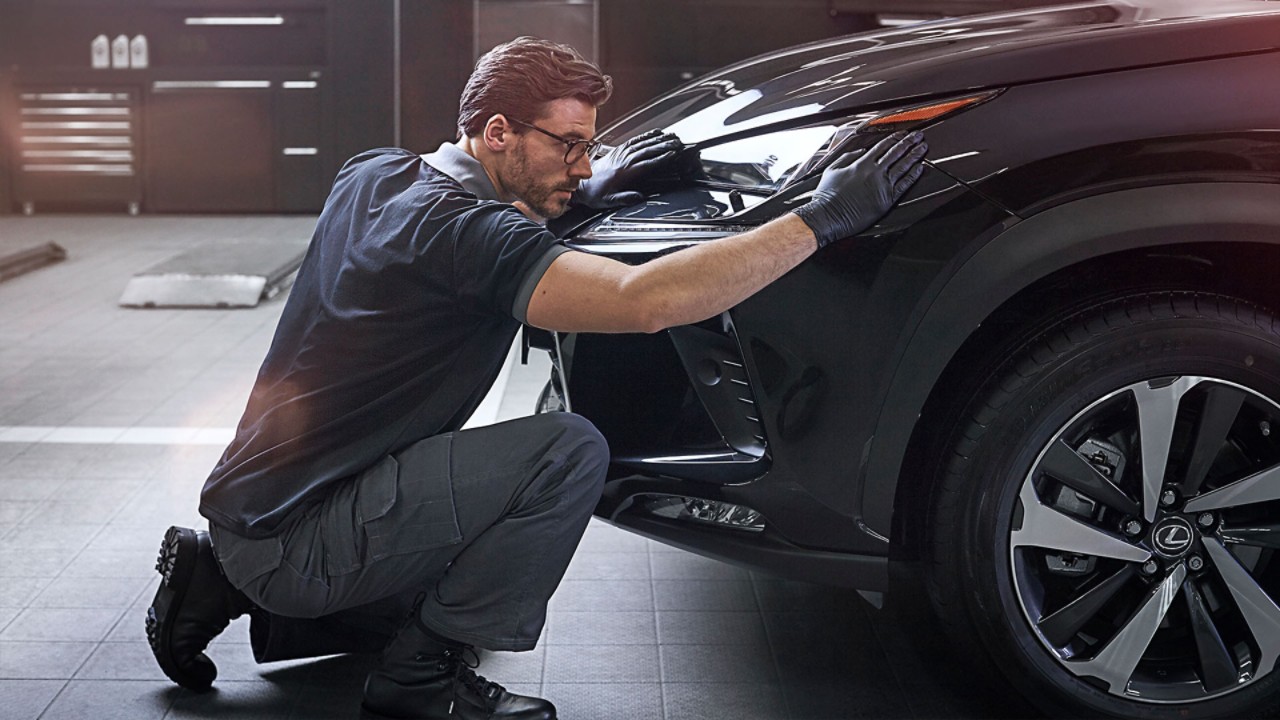 A mechanic next to a Lexus 