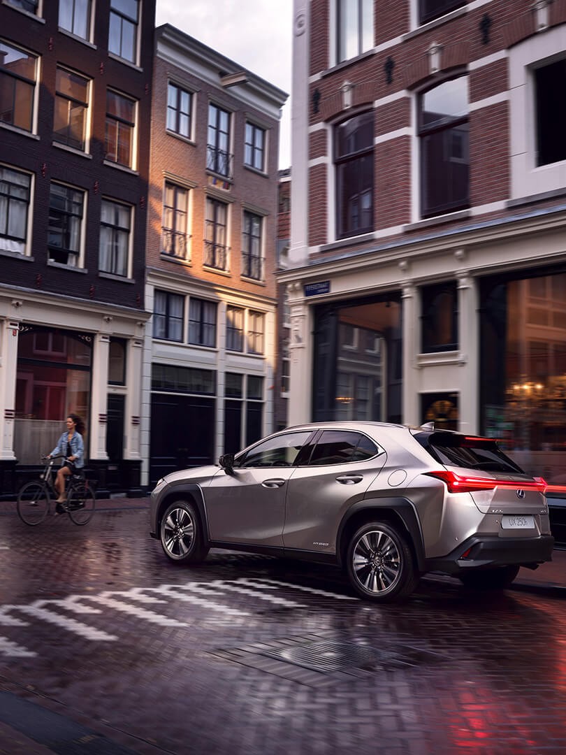 A Lexus UX driving in a city 