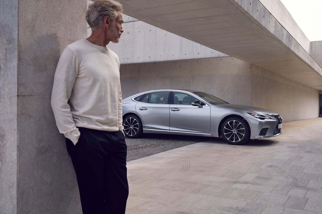 A man standing near a Lexus 