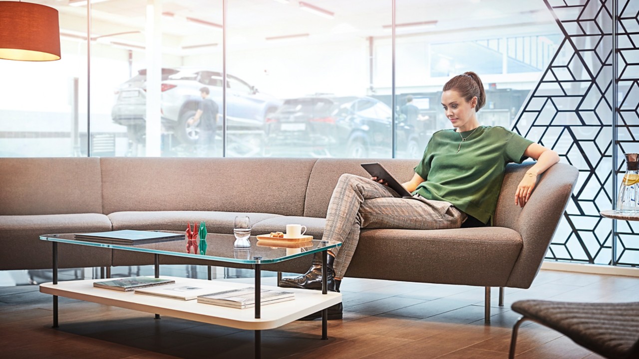 A woman sat on a sofa in a Lexus dealership