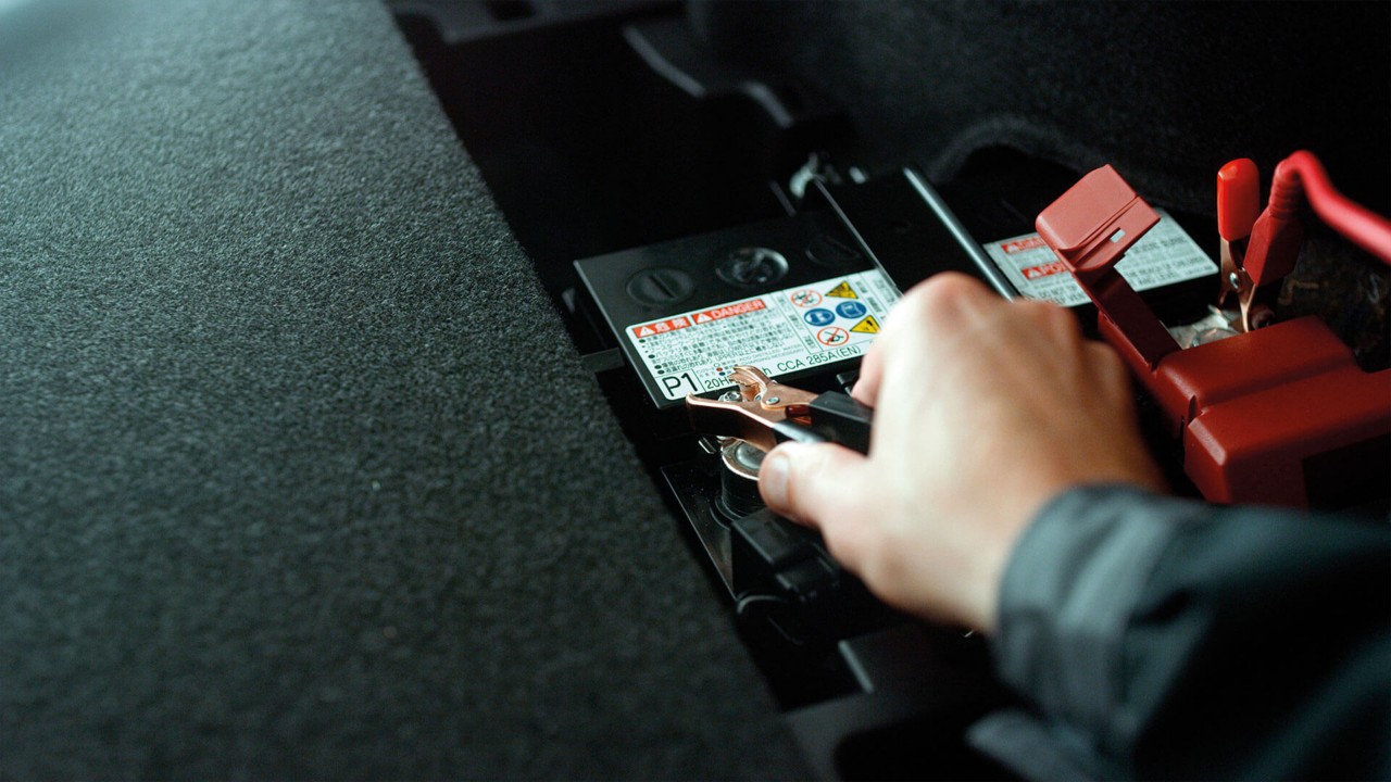 A person connecting a car battery 