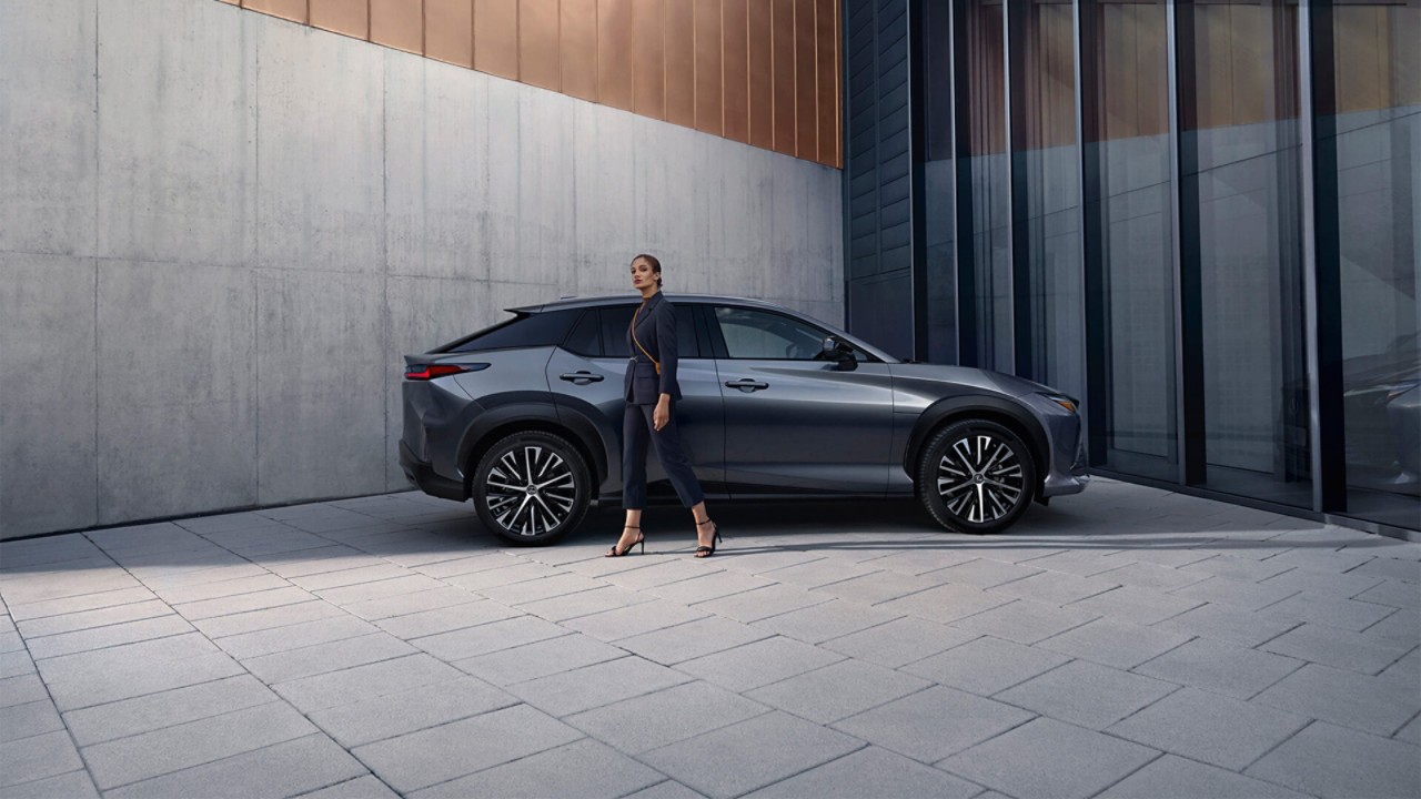 A women next to the Lexus RZ