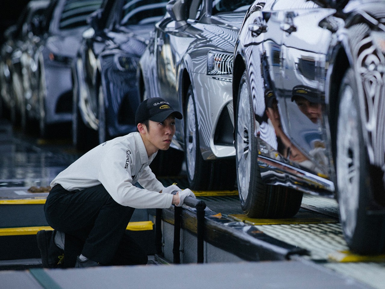 A Lexus mechanic next to an assembly line