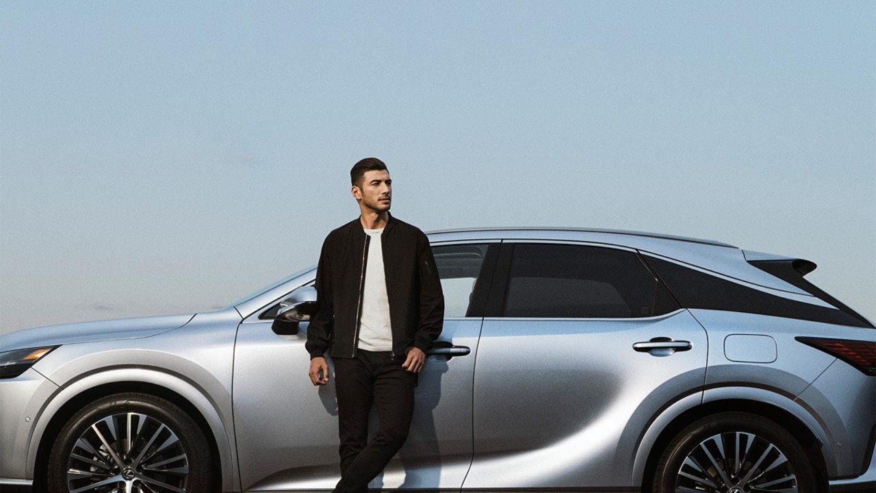 A man leaning against a Lexus RX 