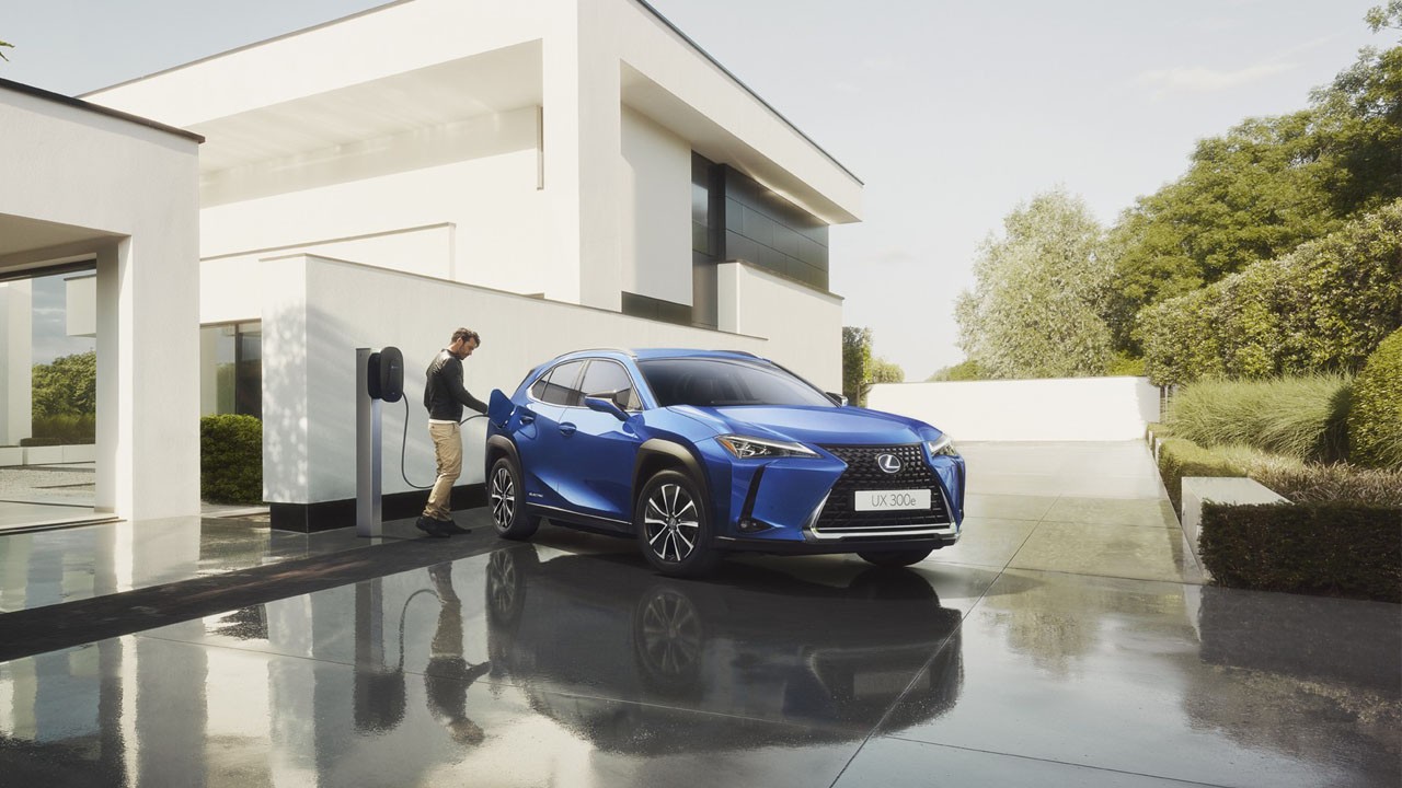 A man plugging in a charger into a Lexus UX 300e 